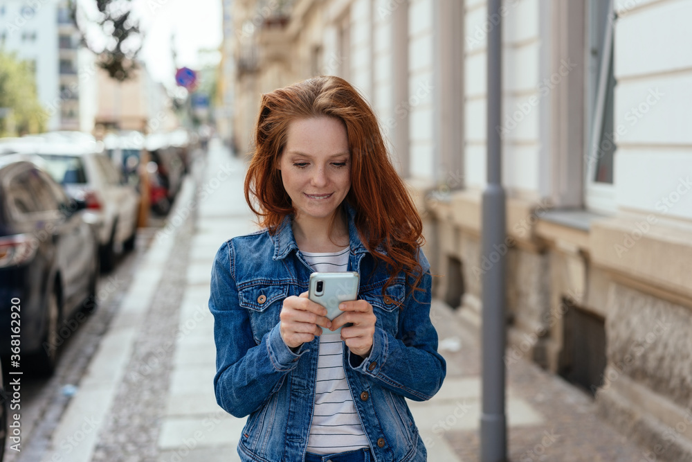 Fototapeta premium Young woman checking a message on her phone