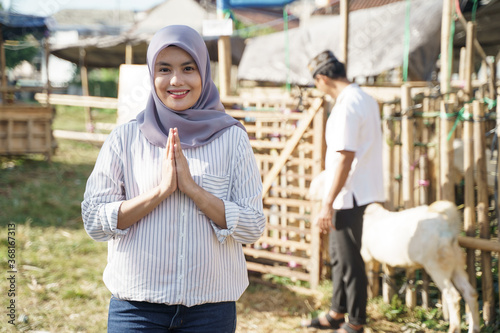 portrait of young muslim woman with goat for idul adha qurban sacrifice © Odua Images