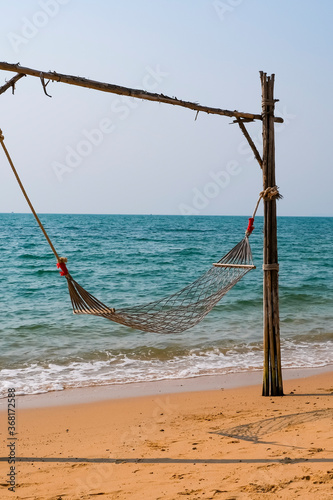 Romantic cozy hammock on the tropical beach by the sea. Peaceful seascape. Relax, travel concept, travelling.