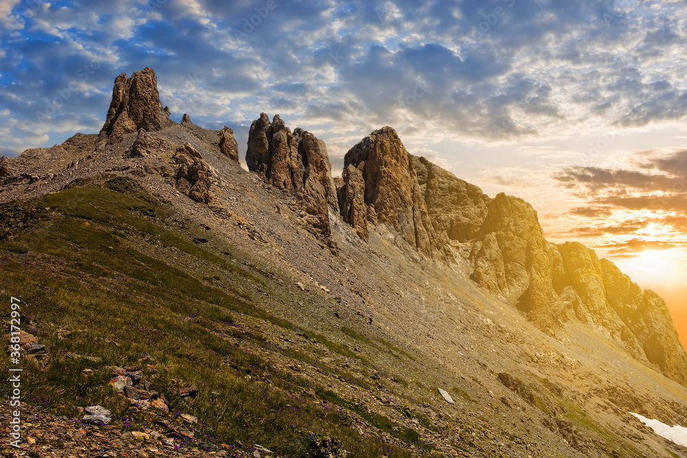 rocky mount slope in a light of evening sun, mountain sunset background