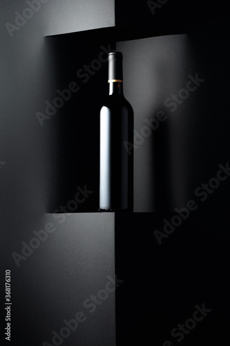 Unopened bottle of red wine on a black background. Copy space.