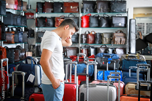 Man choosing suitcase in mo...
