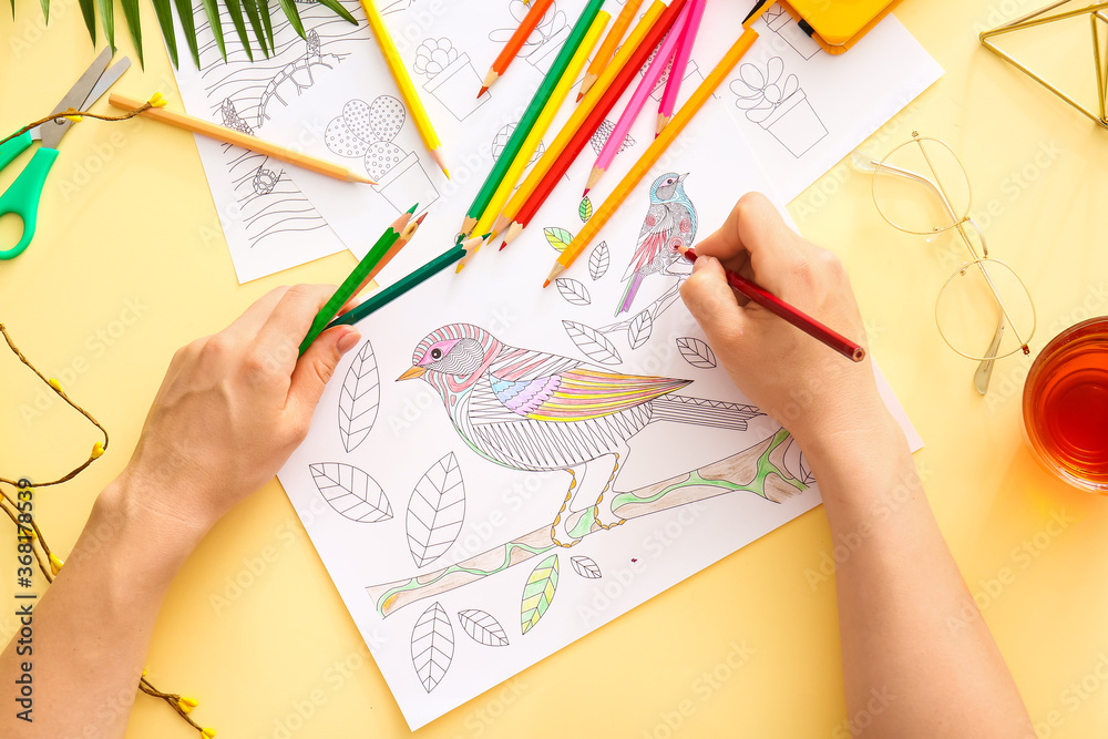 Woman coloring picture at table Woman coloring picture at table