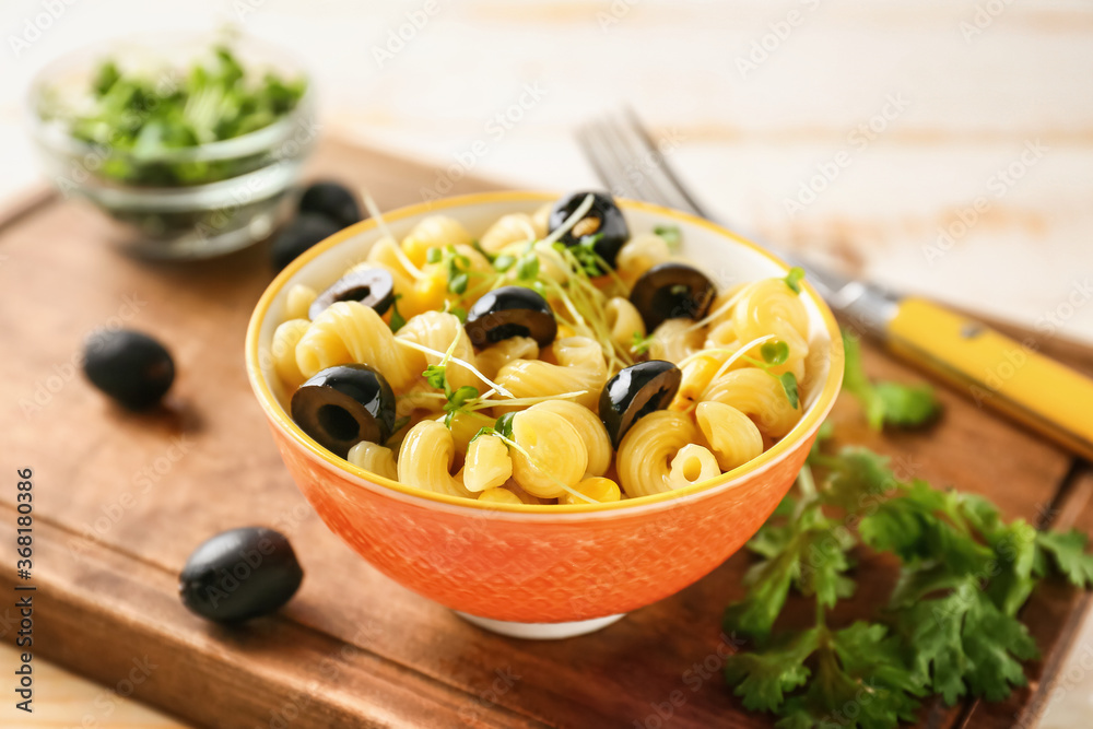 Bowl with tasty pasta salad on table