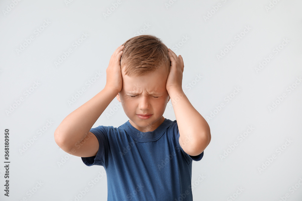 Sad little boy with autistic disorder on light background