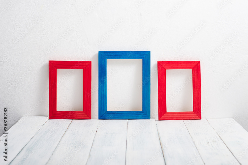 empty red and blue picture frames on white wooden table empty red and blue picture frames on white wooden table