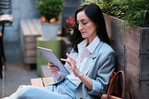 serious businesswoman working with tablet at city cafe