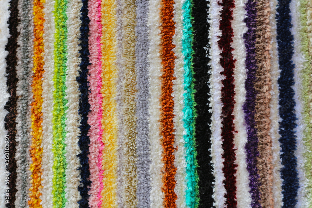 Texture of a multicolored tabby carpet. Abstract striped background.