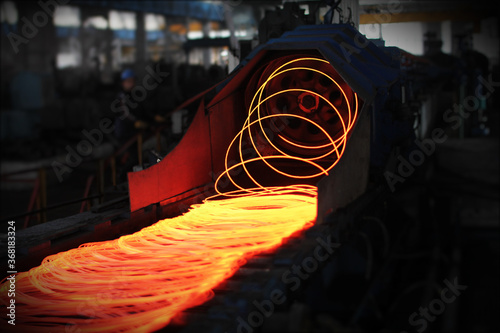 Red hot steel metal wire rods or coils after molten steel casting.  Continuous casting machine. Background of the blacksmith and metallurgical industry.