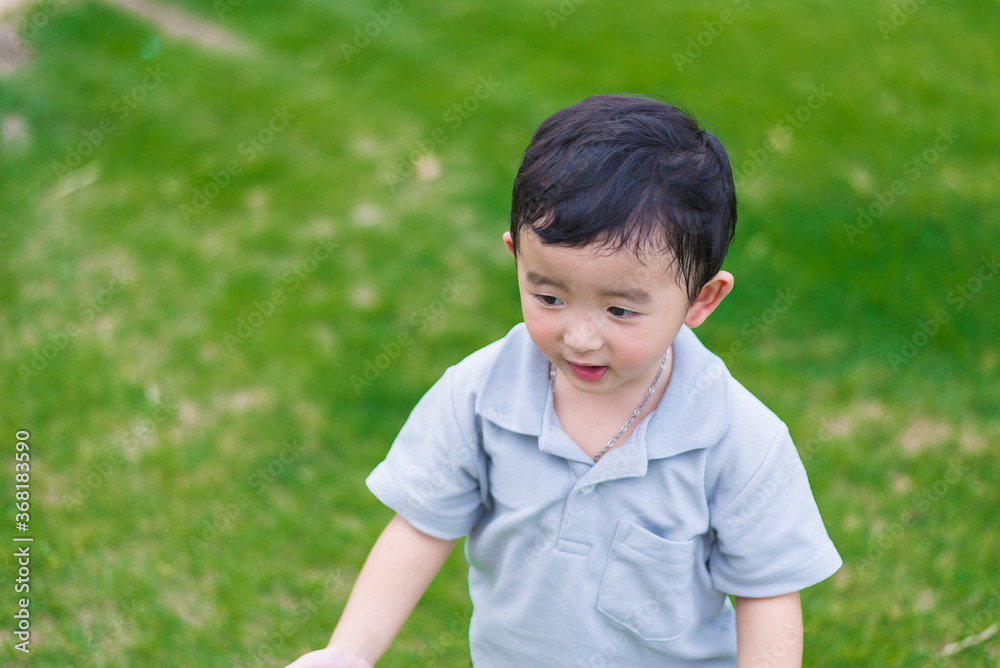 Little Asian kid at the playground under the sunlight, shallow DOF Little Asian kid at the playground under the sunlight, shallow DOF