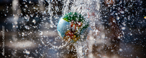 Children's rubber ball rotates on the stream of the fountain