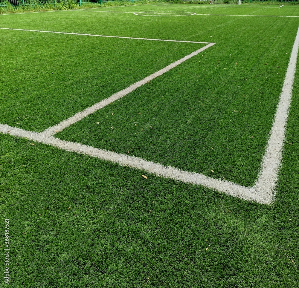 Empty soccer Football on Corner kick line of ball and a soccer field, football field, background texture. Green bright grass is grown for the football field. White stripe on the green soccer field.