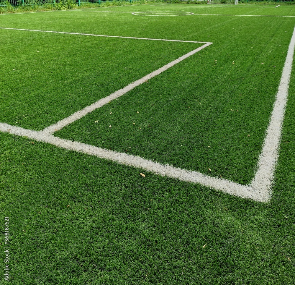 Empty soccer Football on Corner kick line of ball and a soccer field, football field, background texture. Green bright grass is grown for the football field. White stripe on the green soccer field. Empty soccer Football on Corner kick line of ball and a soccer field, football field, background texture. Green bright grass is grown for the football field. White stripe on the green soccer field.