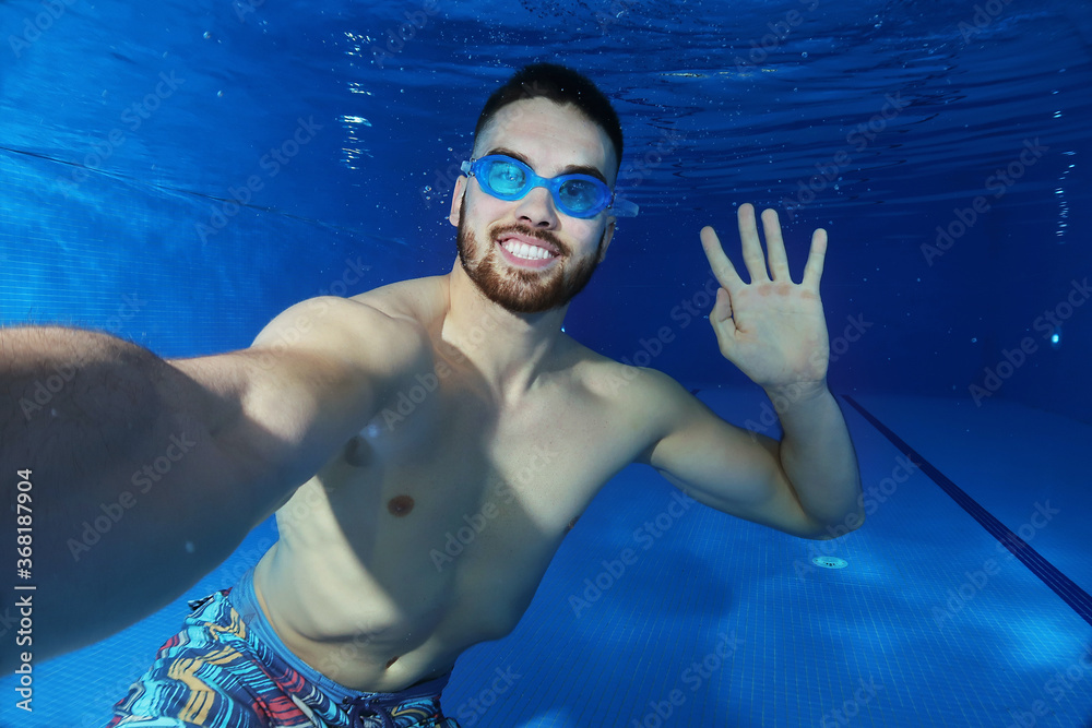 Handsome young man taking a underwater selfie
