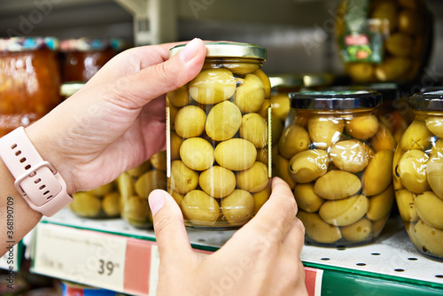Canned olives in hands buyer in shop
