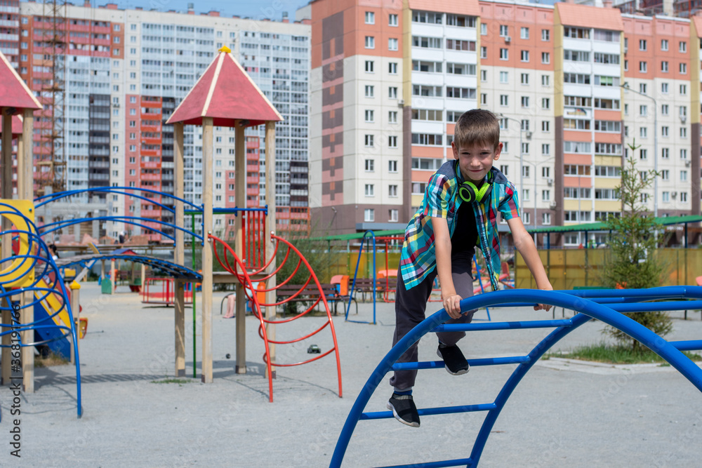 Portrait of a Caucasian little boy going down the crooked frame at the playground. The concept of children's sports
