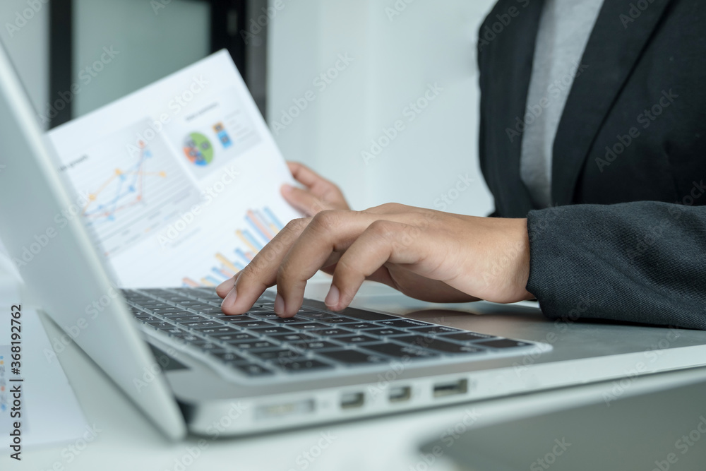The hands of a male businesswoman are analyzing and calculating the annual income and expenses in a financial graph that shows results To summarize balances overall in office The hands of a male businesswoman are analyzing and calculating the annual income and expenses in a financial graph that shows results To summarize balances overall in office