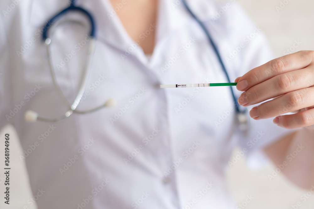 The doctor keeps a positive pregnancy test. The faceless gynecologist recommends the use of rapid pregnancy tests. The doctor keeps a positive pregnancy test. The faceless gynecologist recommends the use of rapid pregnancy tests.