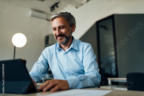 Smiling adult man using modern technology.