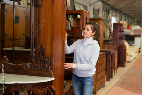 Portrait of young woman looking for furniture at showroom