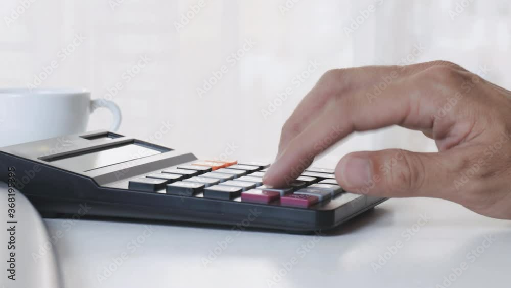 4K man hand using calculator on office desk. Male hand press calculator. Business Man hand using calculator at office. Family budget calculation on wood table. 4K man hand using calculator on office desk. Male hand press calculator. Business Man hand using calculator at office. Family budget calculation on wood table.