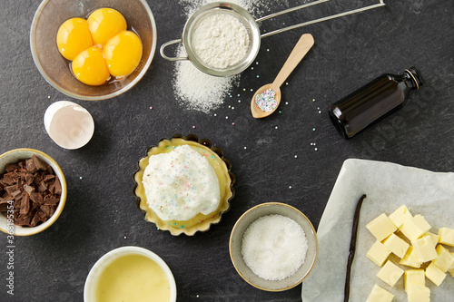 food, culinary and recipe concept - baking dish with dough and cooking ingredients on table