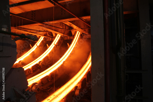 Red hot steel metal billets after molten steel casting.  Continuous casting machine. Background of the blacksmith and metallurgical industry.