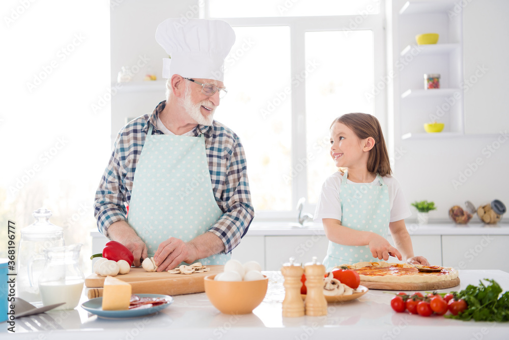 Portrait of his he her she nice cheerful lovely grey-haired granddad grandchild cooking fresh domestic delicious dish dinner naples pizza cookery culinary in modern light white interior kitchen house Portrait of his he her she nice cheerful lovely grey-haired granddad grandchild cooking fresh domestic delicious dish dinner naples pizza cookery culinary in modern light white interior kitchen house