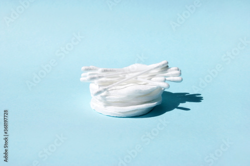 Clean cotton buds on several cotton pads.