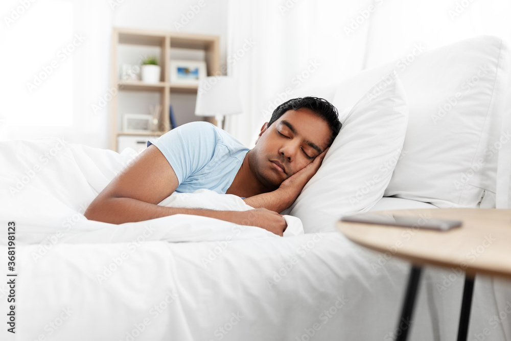 people, bedtime and rest concept - indian man sleeping in bed at home people, bedtime and rest concept - indian man sleeping in bed at home