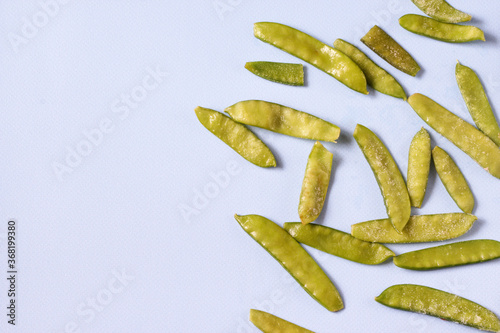 Frozen vegetables such as pea pods on a blue background. Copy space. Top view. Horizontal orientation photo