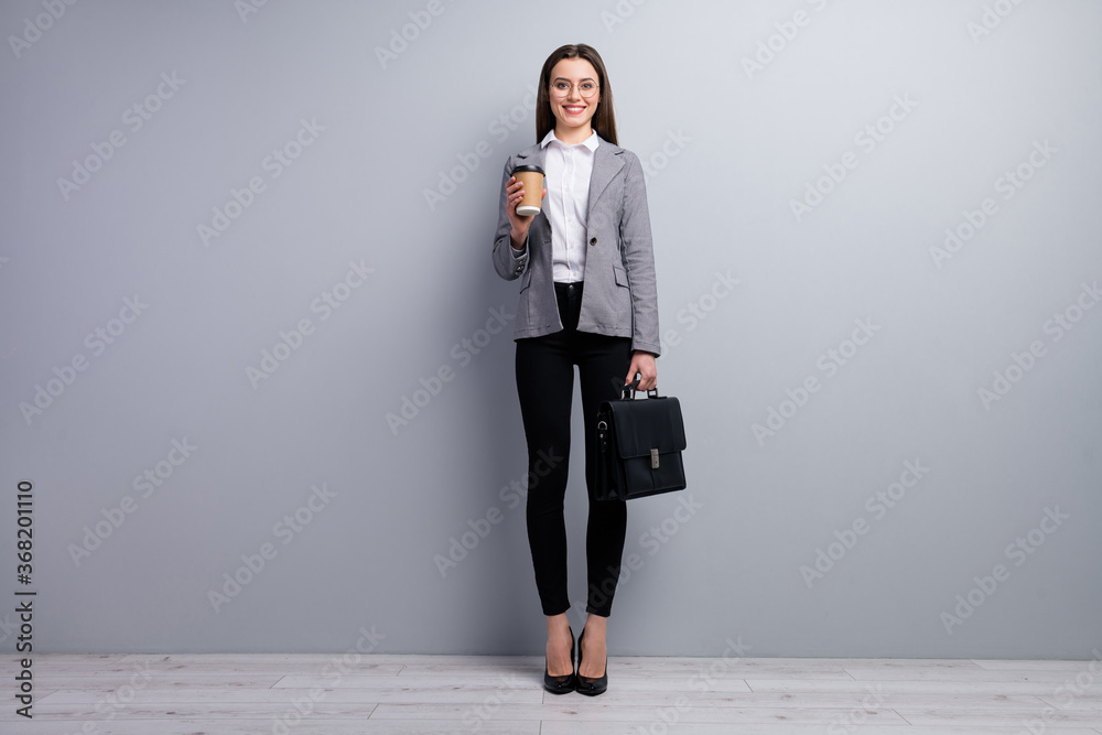 Full size photo of amazing pretty business lady young promoted chief hold diplomat takeout ht fresh coffee beverage wear specs shirt blazer pants high-heels isolated grey color background - obrazy, fototapety, plakaty 