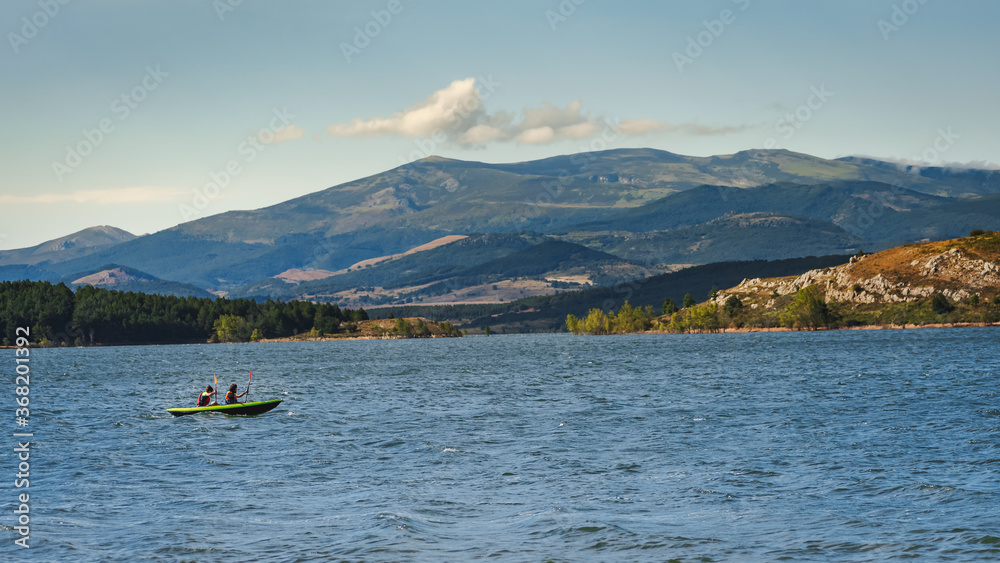 two young athletic men on their kayak canoeing and enjoying the tranquility of Aguilar dam