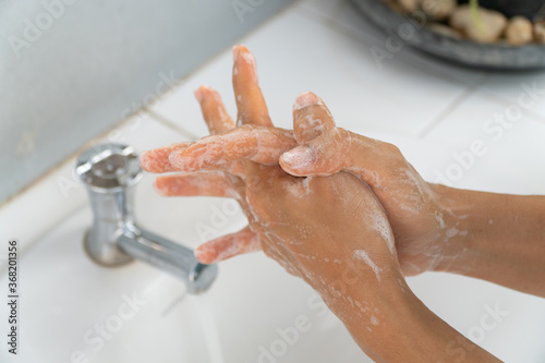 Hands of girl use soap and washing under the water tap. Hygiene concept hand detail. woman washing hands with soap over sink in bathroom.