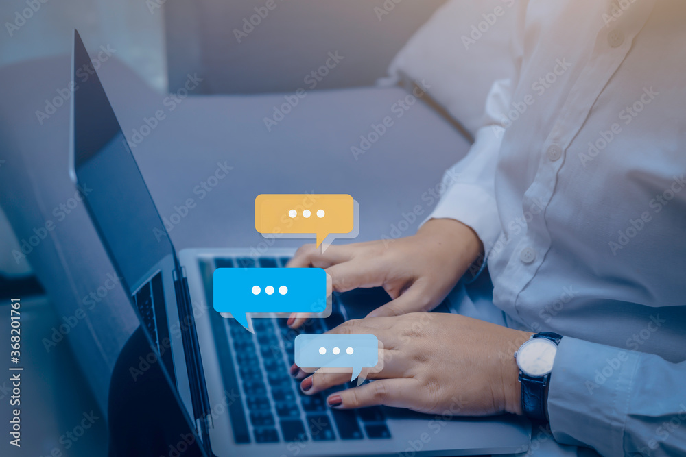 Person hand using computer laptop typing into chat, chatting conversation in chat bubble pop-up. Social media maketing concept. Person hand using computer laptop typing into chat, chatting conversation in chat bubble pop-up. Social media maketing concept.