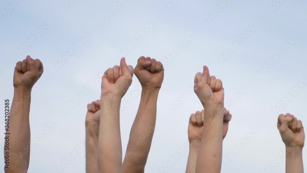 Teamwork. A group of people against the sky raises their hands up. The concept of voluntary voting, expression of consent, support for democracy. Teamwork. A group of people against the sky raises their hands up. The concept of voluntary voting, expression of consent, support for democracy.