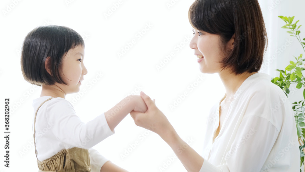 子どもの手を握るお母さん