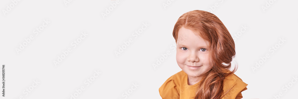 Red hair. Girl head portrait. Attractive little woman. Horizontal banner with copyspace. Sweet smile. Female child model. Funny young person. Positive expression. Looking at camera. Studio shot Red hair. Girl head portrait. Attractive little woman. Horizontal banner with copyspace. Sweet smile. Female child model. Funny young person. Positive expression. Looking at camera. Studio shot