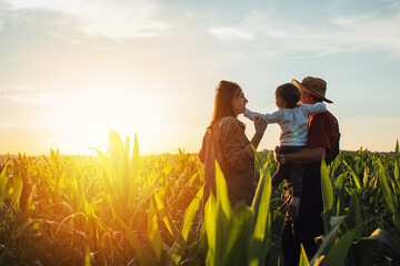 Happy family in corn field. Family standing in corn field an looking at sun rise