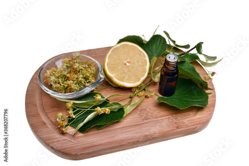 Fresh healthy linden flowers, lemon and tea with essential oil on a white background