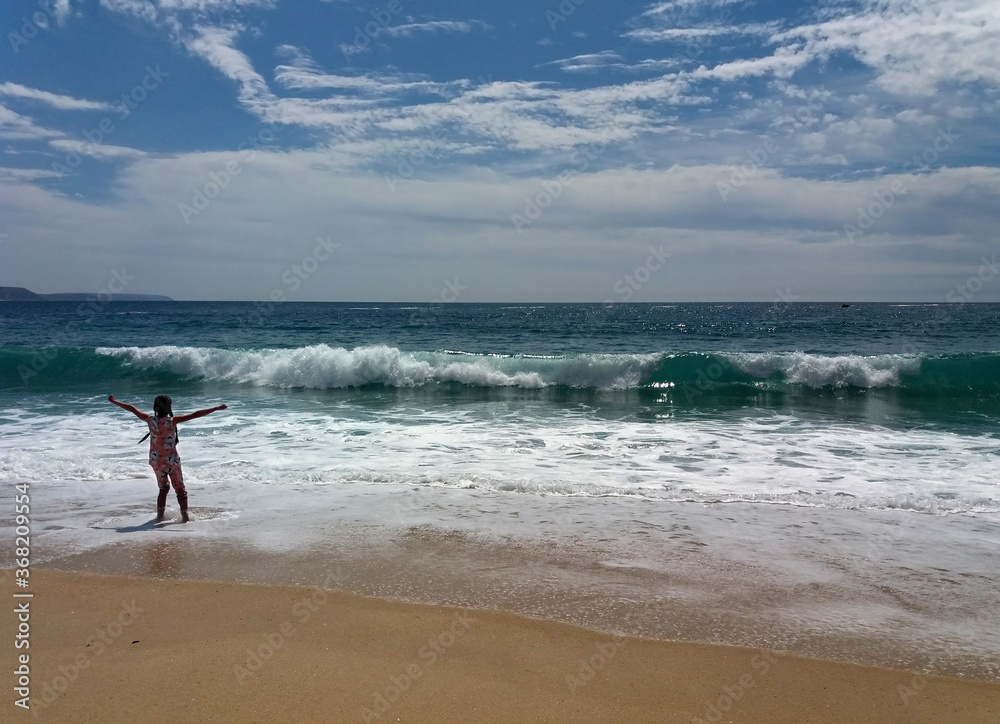The girl enjoys the Atlantic ocean and the waves in the city of Nazare in Portugal The girl enjoys the Atlantic ocean and the waves in the city of Nazare in Portugal