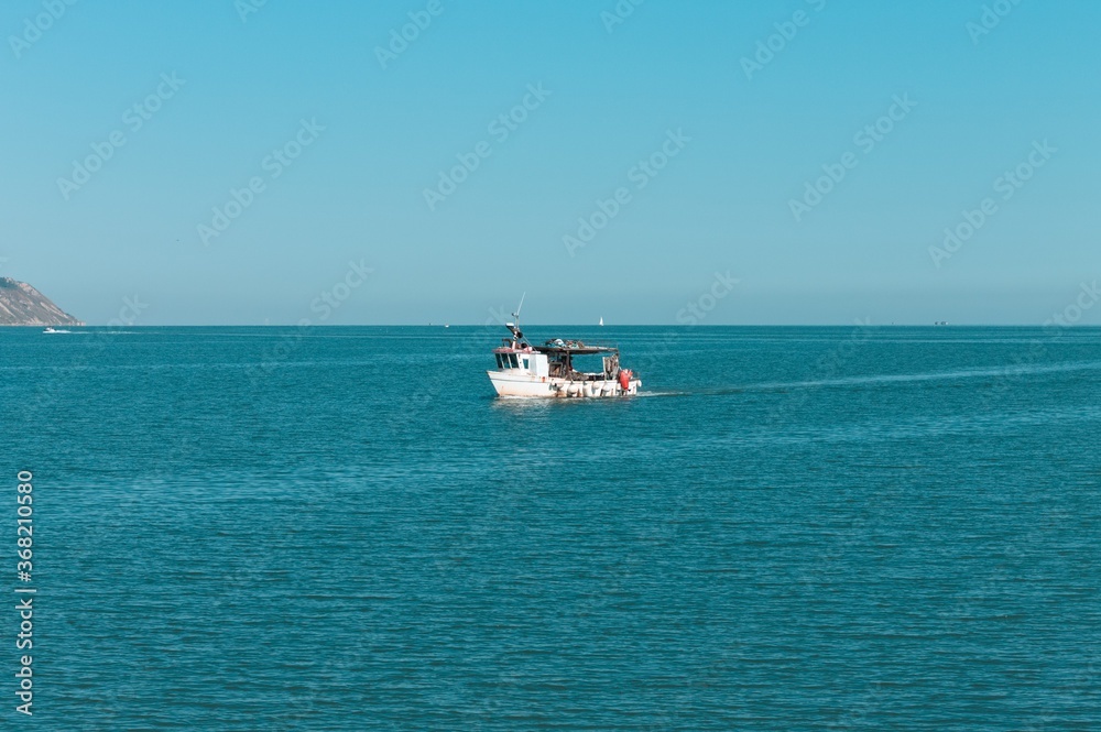 A fishing boat is entering the port in the Mediterranean sea (Pesaro, Italy, Europe)