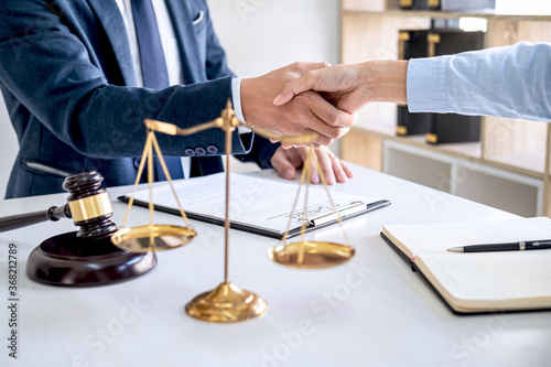 Businesswoman Shaking hands with lawyer after discussing good deal in courtroom