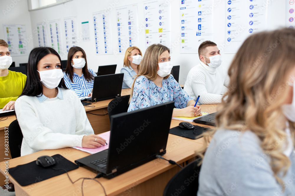 Students with safety masks attending the class and learning new stuff Students with safety masks attending the class and learning new stuff