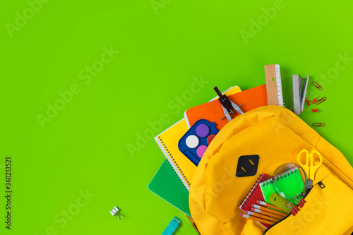 School backpack isolated on green background.