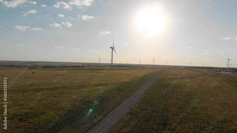 Aerial view of wind turbine on a field in a summer day. Environment friendly and renewable energy concept. Aerial view of wind turbine on a field in a summer day. Environment friendly and renewable energy concept.