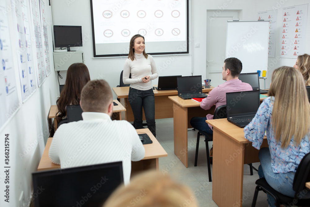 Female driving instructor explaining traffic signs meaning to her students i Female driving instructor explaining traffic signs meaning to her students i