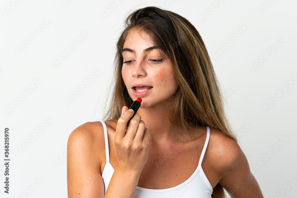 Young caucasian woman isolated on white background holding red lipstick Young caucasian woman isolated on white background holding red lipstick