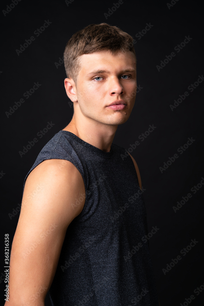Portrait of young man over isolated black background