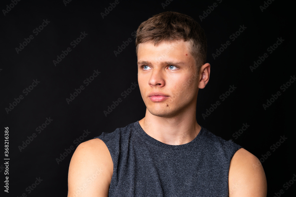 Portrait of young man over isolated black background Portrait of young man over isolated black background